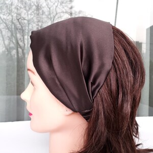 May include: A brown satin headband for hair. The headband is folded and tied at the back of the head.