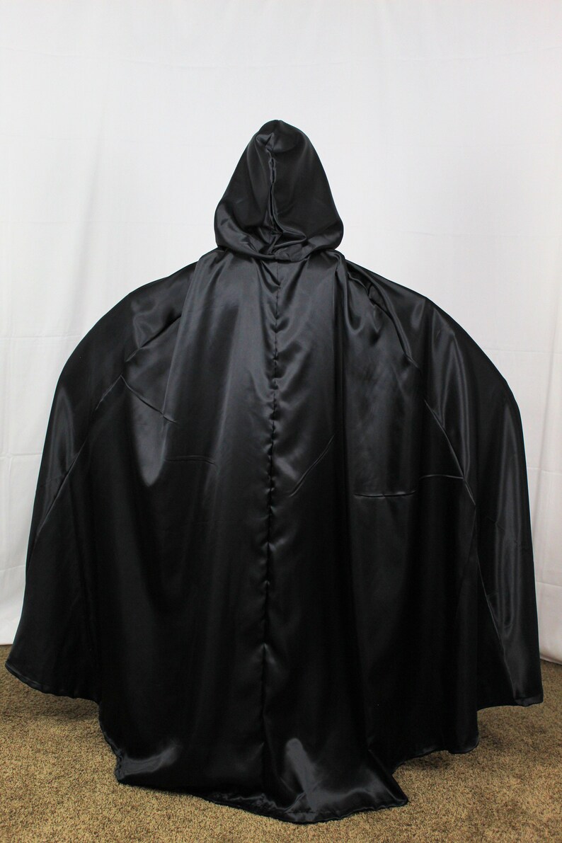 May include: A black satin hooded cape with a long flowing design.