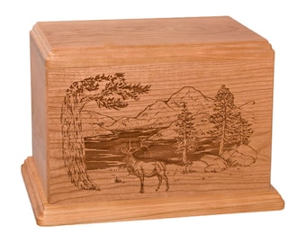 May include: A wooden cremation urn with an engraved design of a mountain scene with a lake, trees, and an elk. The urn is made of cherry wood and has a natural finish.