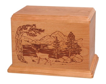 May include: A wooden cremation urn with a laser-engraved design of a deer standing in a forest scene with mountains and a lake in the background.