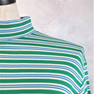 May include: A long-sleeved shirt with horizontal stripes in green, white, and blue.
