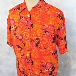 May include: A short-sleeved button-up shirt with a bright orange background and a colorful geometric pattern in shades of pink, orange, and brown.