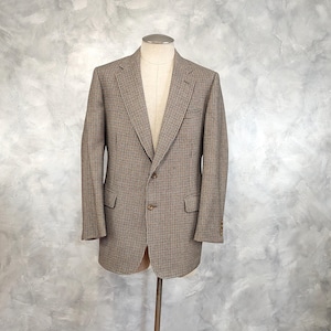 May include: A brown and black plaid blazer with a single button closure. The blazer has a classic fit and is made of a soft, textured fabric.
