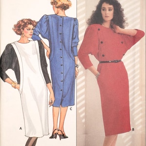 May include: A vintage Butterick sewing pattern featuring illustrations of three different dress designs. The pattern includes a white dress with black sleeves, a blue dress with button details, and a red dress with a belt.