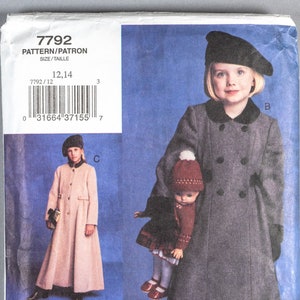 May include: A sewing pattern for a child's coat. The pattern includes three different styles: a red coat with a black trim, a gray coat with a black trim, and a beige coat with a black trim. The pattern is for sizes 12 and 14. The pattern is from Vogue for Me.