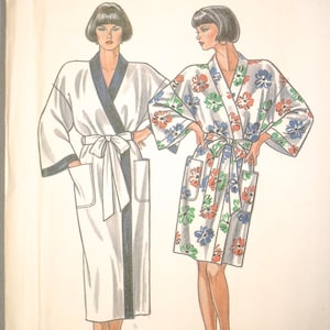 May include: A vintage sewing pattern titled "NEWLOOK 6312" featuring illustrations of two robes. One robe is white with black trim, the other is white with a floral pattern. The word "PATRON" is printed vertically on the left side.