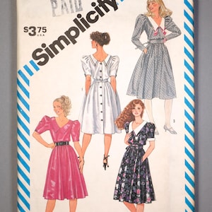 May include: Vintage Simplicity sewing pattern envelope featuring illustrations of four different dresses. The envelope is white with blue diagonal stripes and the Simplicity logo. The price is $3.75.