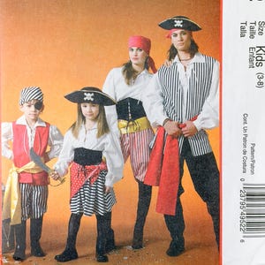 May include: McCall's Costumes M4952 sewing pattern envelope for kids sizes 3-8. The cover features four individuals wearing pirate-themed outfits including white shirts, striped pants, vests, headscarves, and hats, with a yellow and orange background.