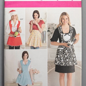 May include: A sewing pattern for four different aprons. The pattern is called Simplicity 2298 and includes sizes A, S, M, and L. The aprons are shown on four different models. The first apron is red with white polka dots and a white collar. The second apron is yellow with white polka dots and a red collar. The third apron is blue with white polka dots and a white collar. The fourth apron is black with white floral print and a white collar.