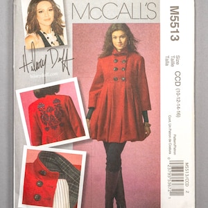 May include: A sewing pattern for a red double-breasted coat with a pleated skirt. The pattern is for sizes 10-12-14-16. The pattern is by McCall's and is called M5513.