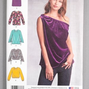 Peut inclure: Patron de couture Simplicity numéro 8788, tailles 14-22, 40-48, 42-50. Le patron comprend des instructions pour réaliser un haut à une épaule. Le mannequin porte un haut en velours violet avec un col froncé et une manche longue. Le patron comprend également des instructions pour réaliser une jupe.