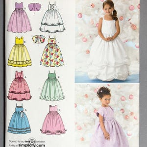 May include: A Simplicity sewing pattern with illustrations of girls' dresses in different styles and colours, including pink, yellow, and blue. The pattern also shows two girls wearing dresses. The text "Simplicity" is displayed at the top.