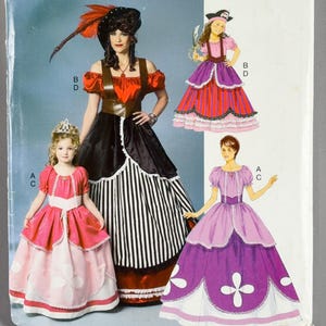 May include: Butterick sewing pattern BP262 for costumes. The envelope features illustrations of three different dress styles: a pirate-themed outfit with a black and white striped skirt, a pink and white dress, and a purple and white dress.