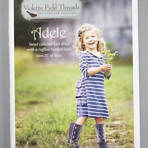 May include: A sewing pattern for a sweet collared knit dress with a ruffled bustled back. The pattern is called "Adele" and is for sizes 2T-10 years. The pattern is from Violette Field Threads, patterns and tutorials.