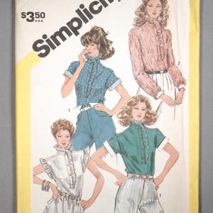 May include: Simplicity pattern envelope featuring illustrations of blouses with ruffled collars and short sleeves. The blouses are in various colors and patterns, including polka dots and stripes. The envelope has the number 5848.
