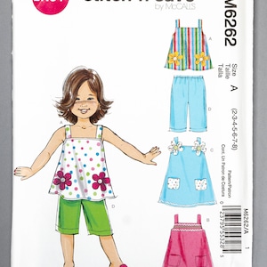 May include: A sewing pattern for a girl's dress and shorts. The pattern is called "stitch 'n save" and is by McCall's. The pattern number is M6262. The pattern includes instructions for making a dress with a floral print and a pair of green shorts.