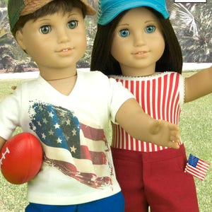 May include: Two dolls wearing summer outfits. The doll on the left is wearing a white t-shirt with an American flag design, blue shorts, and a brown and green baseball cap with an eagle design. The doll on the right is wearing a red and white striped tank top, red shorts with a small American flag patch, and a blue baseball cap with a red lobster design. The text "LEE & PEARL" is visible in the top right corner of the image.