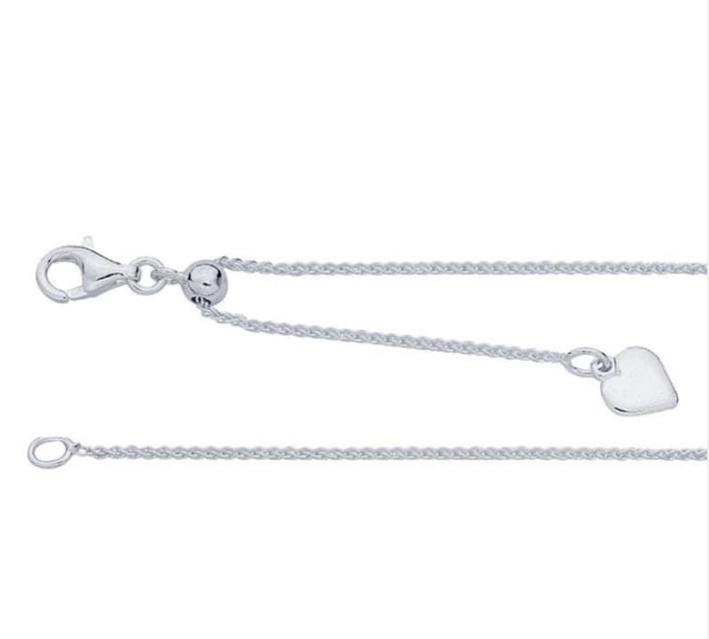 May include: A silver chain necklace with a heart charm and a sliding bead to adjust the length.