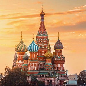 May include: A red, green, and gold onion-domed cathedral with intricate details against a sunset sky.