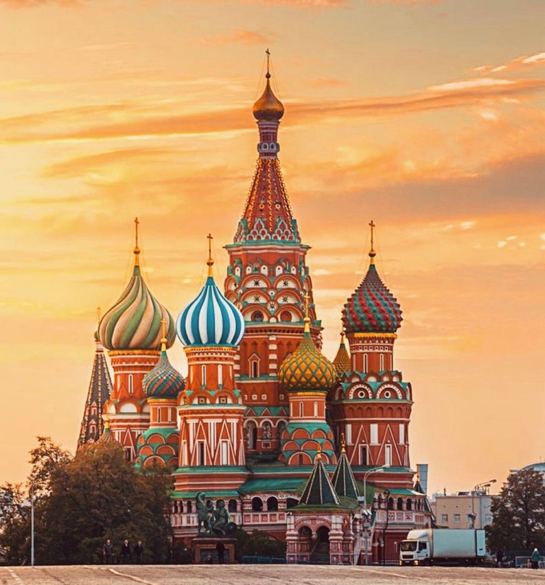 May include: A red, green, and gold onion-domed cathedral with intricate details against a sunset sky.