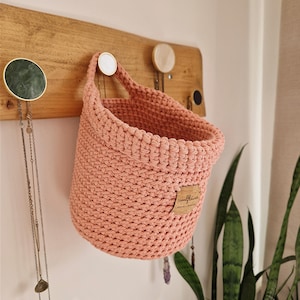 Light pink crochet hanging wall basket, perfect for nurseries, bathrooms, bedrooms, hallways and kitchens! Organise nappies, teddies, pegs, keys, jewellery and anything else in this cotton storage and wall decoration. Made by WoolflowerDesigns on Etsy