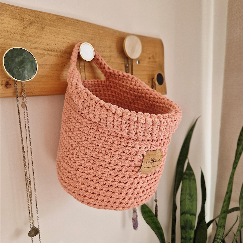 Light pink crochet hanging wall basket, perfect for nurseries, bathrooms, bedrooms, hallways and kitchens! Organise nappies, teddies, pegs, keys, jewellery and anything else in this cotton storage and wall decoration. Made by WoolflowerDesigns on Etsy