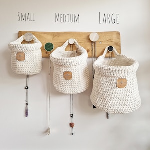 3 natural coloured crochet hanging storage baskets in small, medium and large. Great for nursery, bathroom, bedroom and hallway organisation and storage. Found on Etsy, by Woolflower