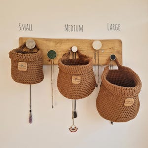 Brown crochet hanging baskets, perfect storage for organising bedrooms, bathrooms, kitchens and nurseries, on Etsy by Woolflowerdesigns. A great new home and house warming gift.