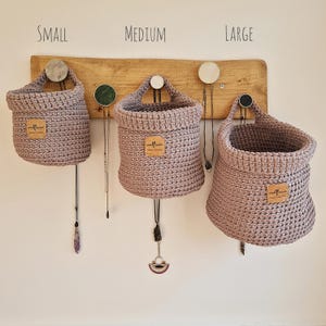 Warm grey crochet hanging baskets, perfect storage for organising bedrooms, bathrooms, kitchens and nurseries, on Etsy by Woolflowerdesigns. A great new home and house warming gift.