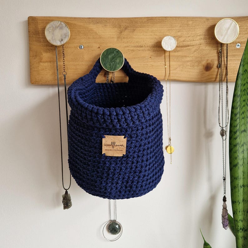 A navy blue cotton sample to make in to hanging crochet baskets with a vegan friendly cork "woolflower" logo. Great for bedrooms, bathrooms and nursery for storing toiletries, make-up, vitamins, pegs, etc. Natural home organisation on Etsy by Woolflowerdesigns!