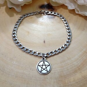May include: A silver chain bracelet with a silver pendant featuring a pentagram symbol.