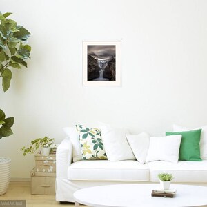 May include: A framed photograph of a waterfall cascading down a rocky cliff. The image is in black and white and has a vintage feel.