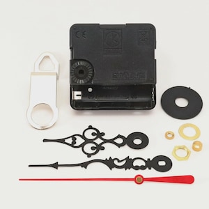 May include: Clock making kit with black clock movement, silver hanger, black hands, red second hand, and various brass and black hardware. The kit includes a black rubber washer and a black plastic washer.