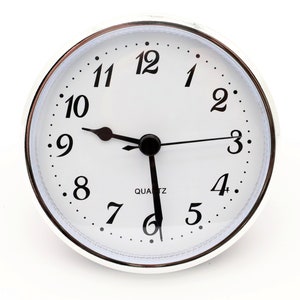 May include: A white analog clock with black hands and black numbers on a silver face. The clock face has a silver rim and a silver bezel. The clock is set to 10:10 and reads "QUARTZ".