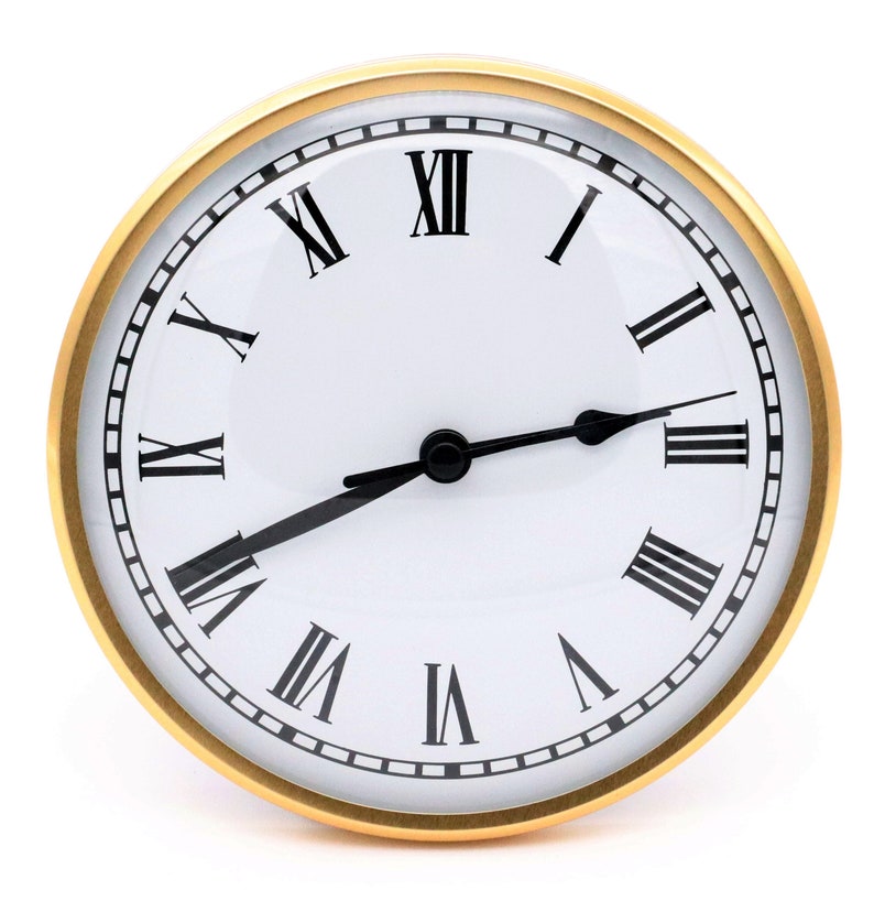 May include: A round clock face with a white background, black Roman numerals, and black hands. The clock has a gold-colored bezel. The hands indicate the time is approximately 3:40.
