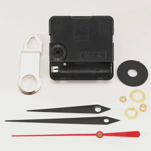 May include: Clock movement kit with black clock hands, a red second hand, and various hardware components. Includes a black clock motor, a silver hanger, and a black rubber washer. Ideal for DIY clock projects.