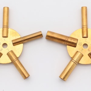 May include: Two sets of watch key winders with five different sizes. Each set has a brass base with numbers 2, 3, 4, 5, 6, 7, 8, 9, 10, and 11 printed on it.