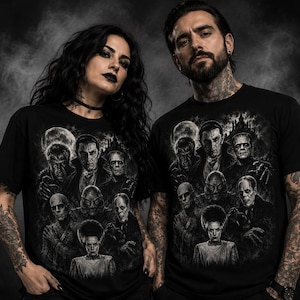 May include: A black t-shirt featuring a detailed monochromatic graphic print of classic horror movie monsters, including Dracula, Frankenstein's monster, the Mummy, the Creature from the Black Lagoon, and the Bride of Frankenstein under a full moon.