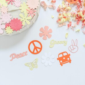 May include: A collection of paper cutouts in various colors and shapes, including peace signs, flowers, butterflies, and the words "Peace" and "Groovy".