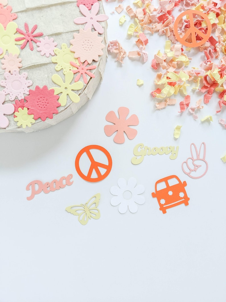 May include: A collection of paper cutouts in various colors and shapes, including peace signs, flowers, butterflies, and the words "Peace" and "Groovy".