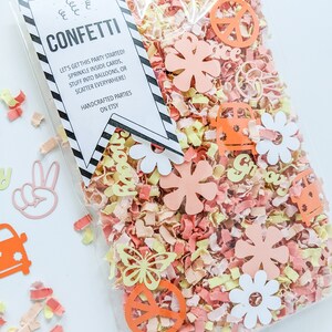 May include: A clear plastic bag filled with confetti. The confetti is made of paper and features peace signs, flowers, butterflies, and the word "groovy". The bag also includes a tag that reads "Confetti Let's get this party started! Sprinkle inside cards, stuff into balloons, or scatter everywhere! Handcrafted parties on Etsy."