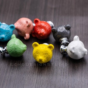 May include: Assortment of colorful ceramic bear-shaped drawer pulls with silver hardware.