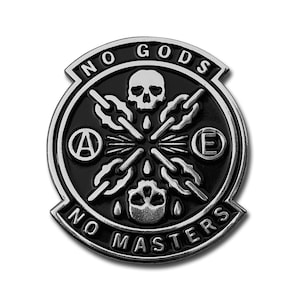Pode incluir: Um alfinete de metal preto e prateado com as palavras "NO GODS NO MASTERS" na borda. O alfinete apresenta uma caveira, correntes e símbolos. O alfinete é redondo com formato de escudo.