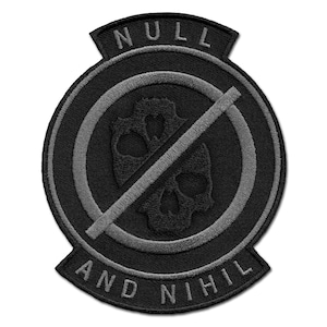 Pode incluir: Patch bordado preto com as palavras "NULL" e "AND NIHIL". O patch apresenta um desenho de caveira dentro de um círculo com uma linha diagonal. O patch é de cor cinza escuro.
