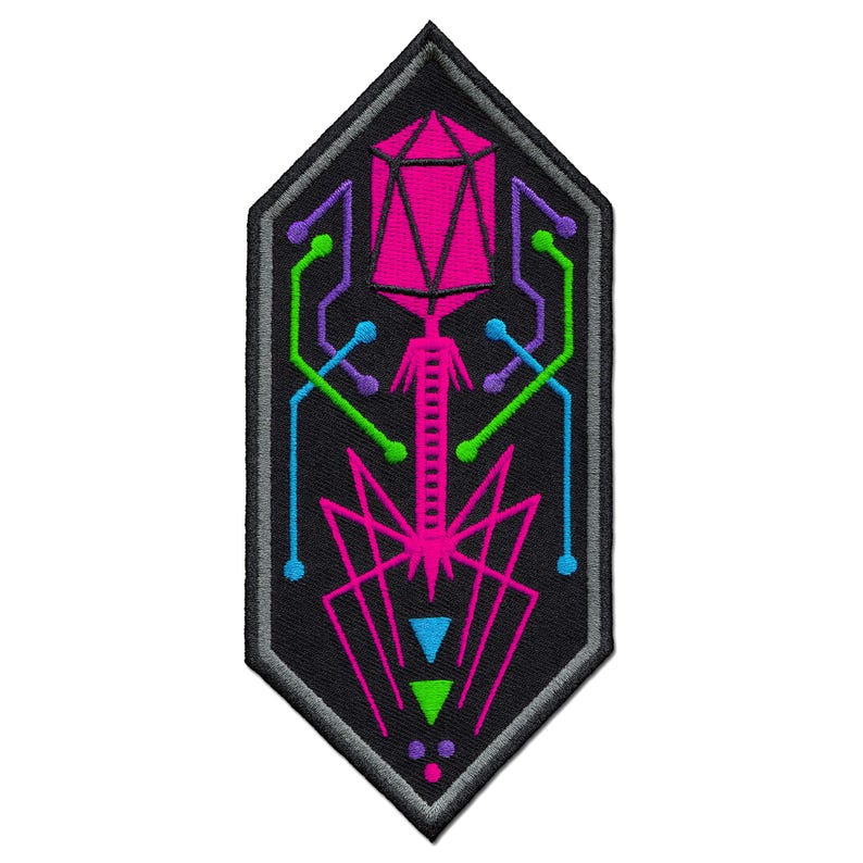 May include: Embroidered patch with a geometric design in a shield shape. The patch features a black background with a pink, green, blue, and purple design. The design includes a geometric shape at the top, lines, and dots.