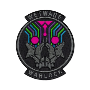 Op de afbeelding: Zwarte en grijze geborduurde patch met de tekst "WETWARE WARLOCK" in een cirkel. Het midden van de patch toont een gestileerde schedel met gloeiende roze ogen en een kleurrijk printplaatontwerp.
