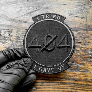 K&ouml;nnte beinhalten: Ein schwarzer Aufn&auml;her mit dem Text "I TRIED" oben und "I GAVE UP" unten. Die Zahl "404" befindet sich in der Mitte, durchgestrichen. Der Aufn&auml;her ist rund mit einem grauen Rand.