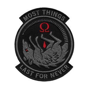Puede incluir: Un parche bordado negro y gris con el texto "Most Things Last For Never" en un círculo alrededor de un lobo gris con un símbolo omega rojo y una gota de sangre roja encima.