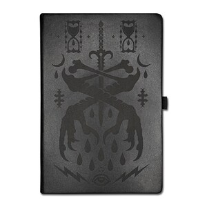May include: Black journal with a debossed design featuring a sword, crossed bones, and bird claws. The cover also includes hourglasses, crescent moons, teardrops, lightning bolts, and an eye. A black elastic band secures the journal.