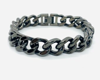 Puede incluir: Un brazalete de cadena negro con cierre de broche.
